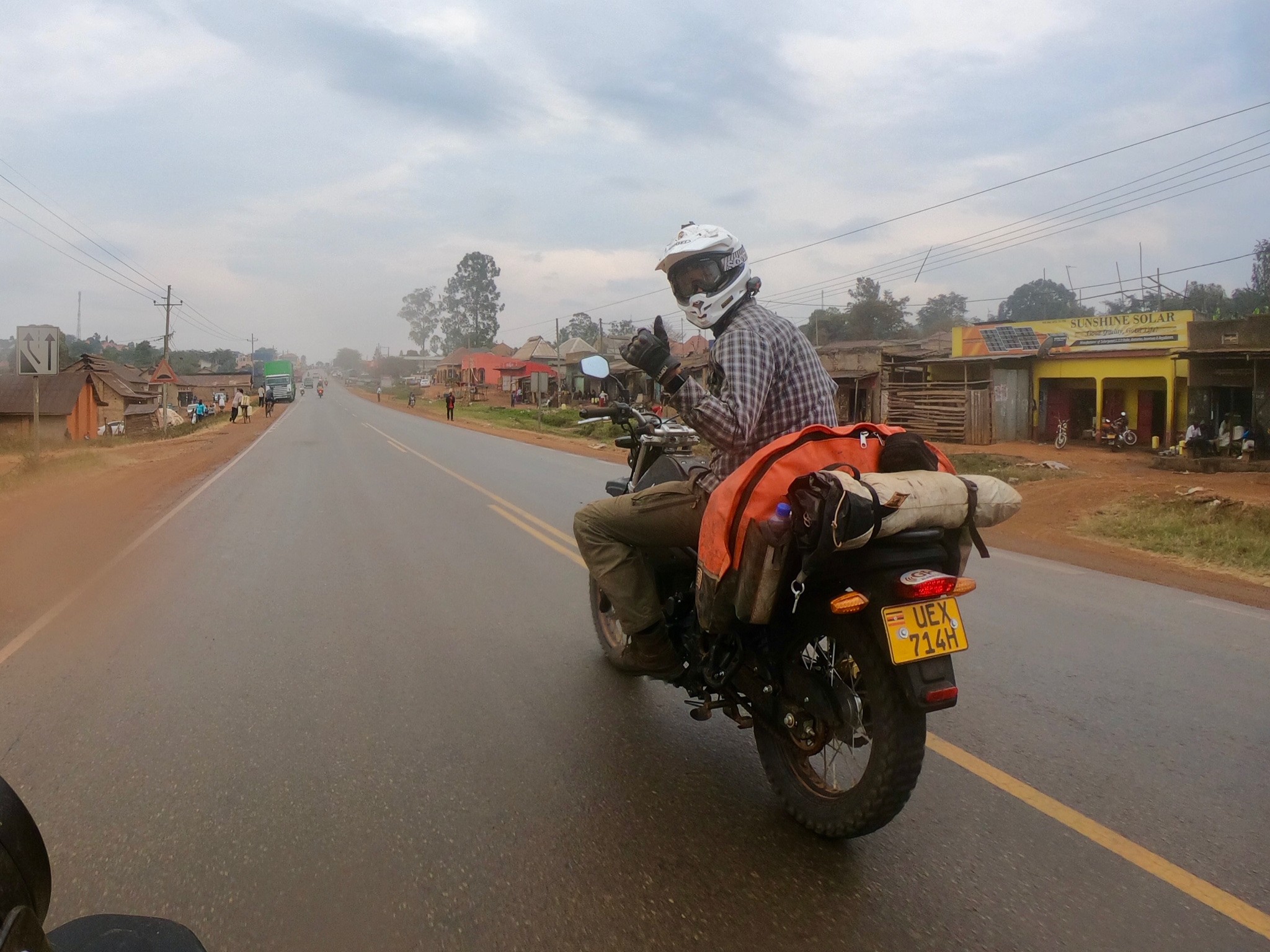 motorradreise-uganda-gluecklicher-fahrer-dorfstrasse