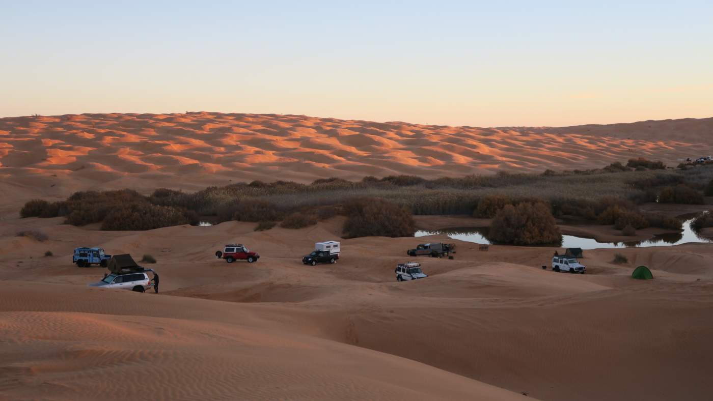 Das letzte Licht des Tages taucht die Sahara in orange-rote Farben
